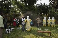 A member of the Congolese Red Cross trains a group of volunteers about how to wear protective equipment and disinfect the home of someone with Ebola.